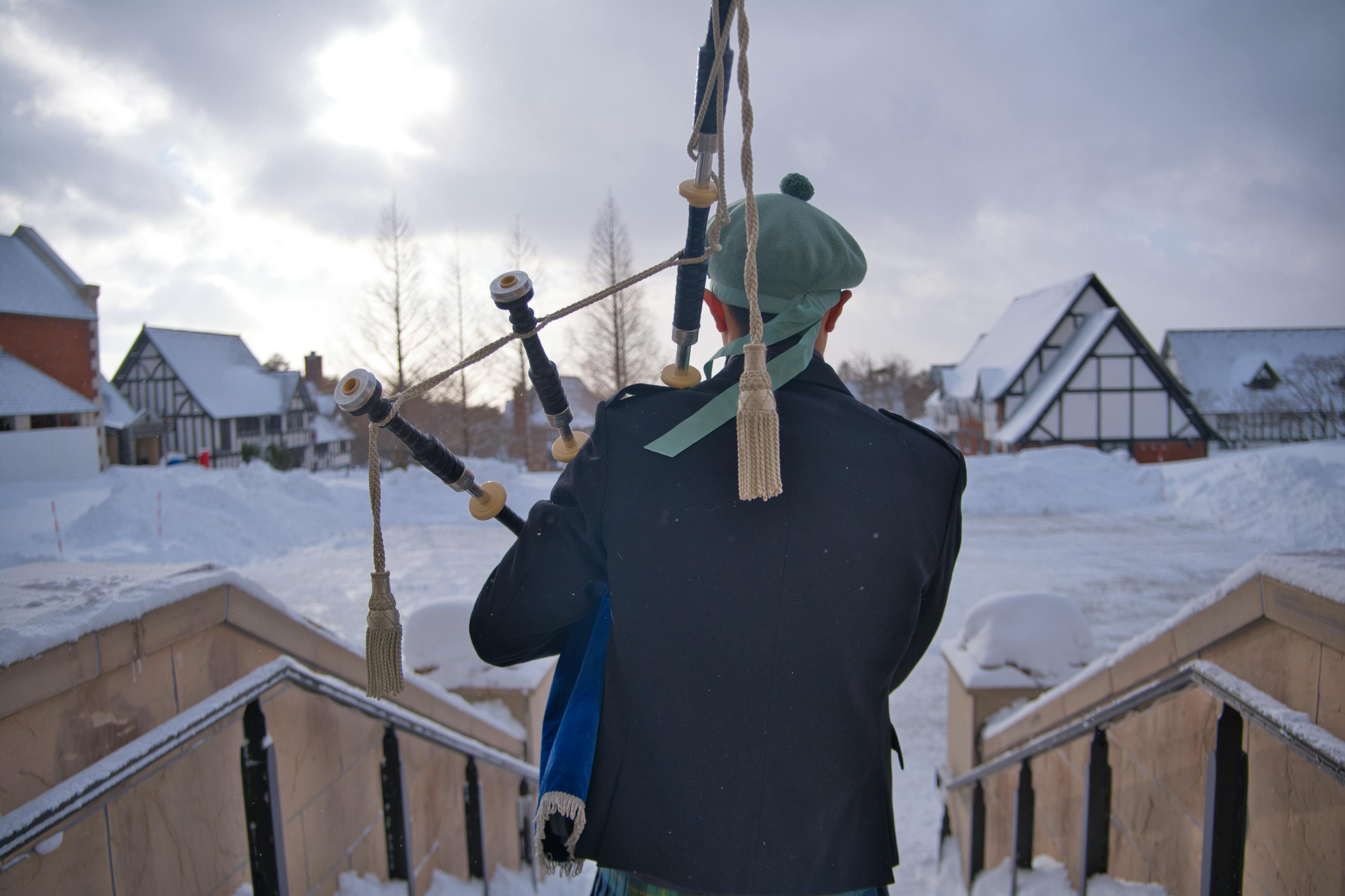 A bagpiper playing outdoors in a snowy winter scene